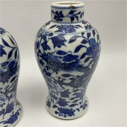 Pair of late 19th/early 20th century Chinese blue and white vases, each of baluster form, painted with dragons amidst flowers, each with Kangxi character marks beneath, H14cm 