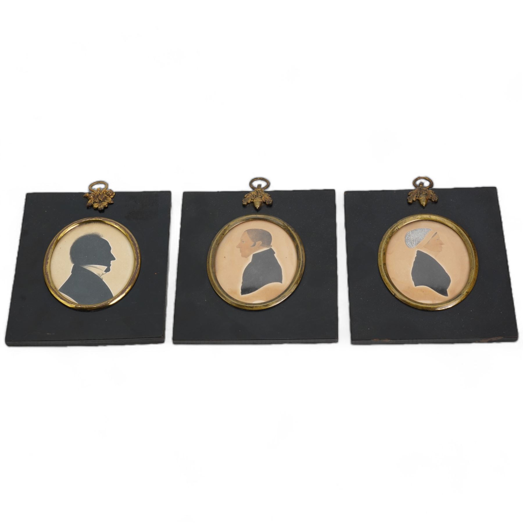 Pair of 19th century oval hand-coloured silhouettes of 'The Reverend D Isaac - Preacher of the Gospel 1859' and 'Mrs D Isaac Coningsby', in ebonised frames; together with another similar 13cm x 11cm (3)