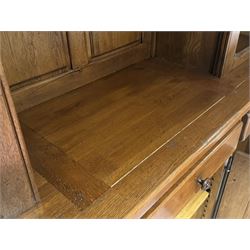 Large 20th century oak dresser, projecting cornice over open arched central section with two shelves, flanked by two panelled cupboards with two shelves, lower section with three drawers above three cupboards, on stile supports 