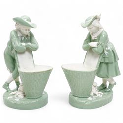 Pair of Minton green glazed spill vases, modelled as two vintners leaning over baskets, im...