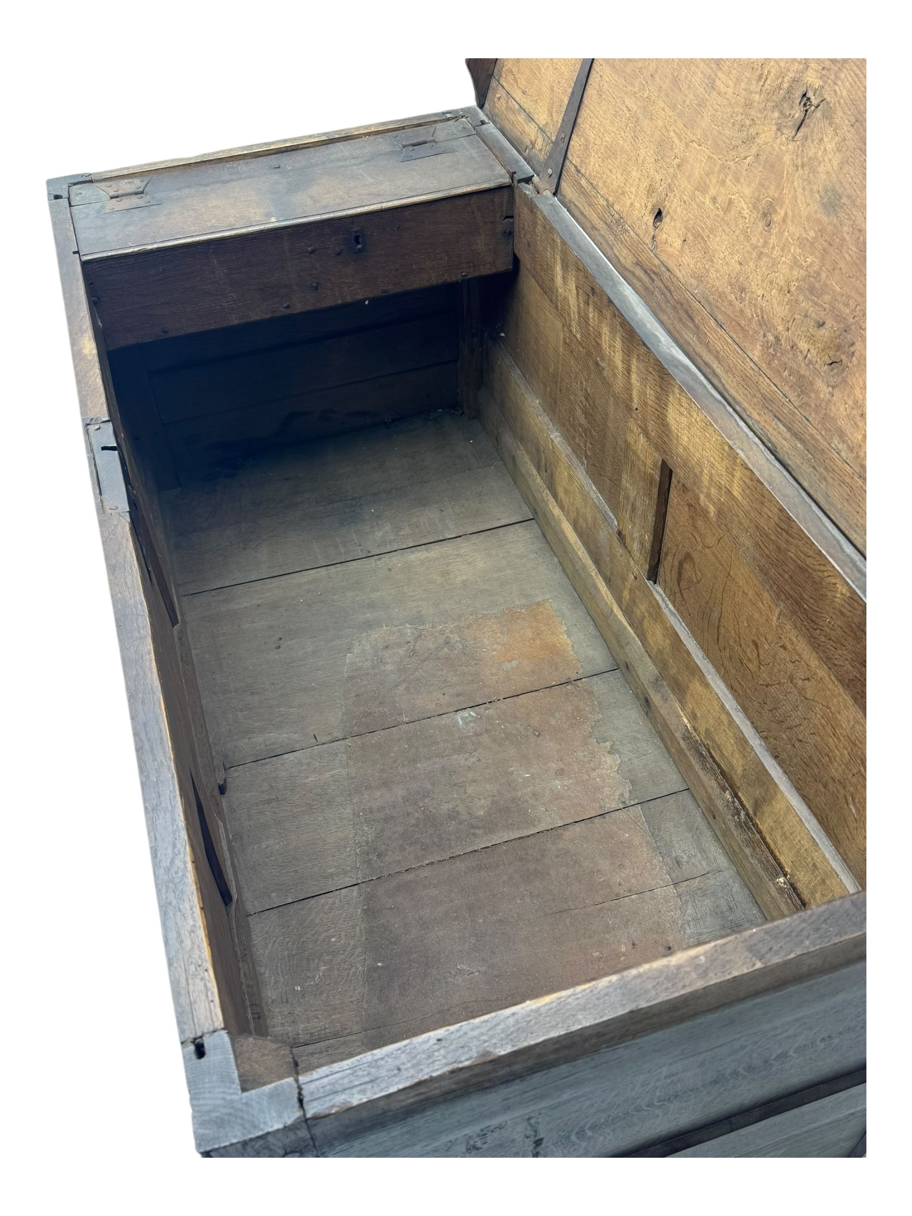 18th century oak mule chest, rectangular plank top with moulded edge, enclosing candle box with internal divisions, panelled front with applied moudlings, fitted with single drawer to the base with brass swing handle, on stile supports