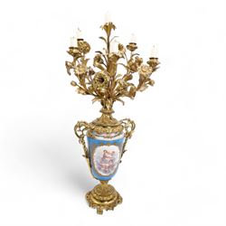 Pair of 19th century Sevres pattern porcelain and ormolu six light candelabra, each with branches cast as lilies, carnations etc, the two handled vase shaped base with oval panels painted with cherubs amongst flowers on a bleu de ciel surround and raised on an ormolu foliate stem and circular base with scrolling bracket feet H76cm (2)  