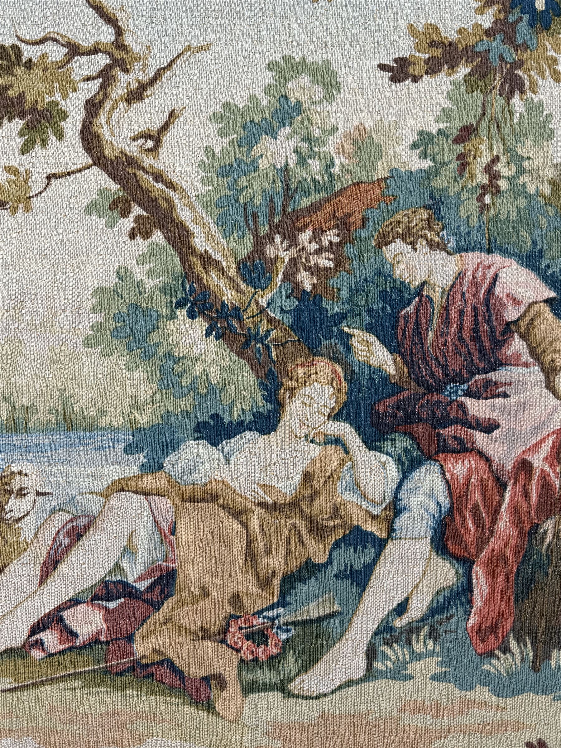 Large French machine woven tapestry, depicting figures in a landscape with a floral boarder 