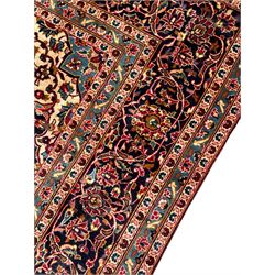 Persian Kashan crimson ground carpet, floral pattern pole medallion surrounded by trailing branches with foliate motifs and palmettes, scrolling border decorated with stylised plant motifs, within multiple guard stripes