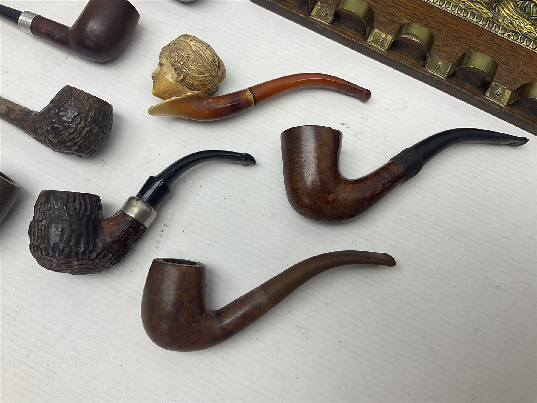 Collection of smoking pipes including Meerschaum pipe, carved as a female head, Briars and clay examples, etc and four pipe racks/stands