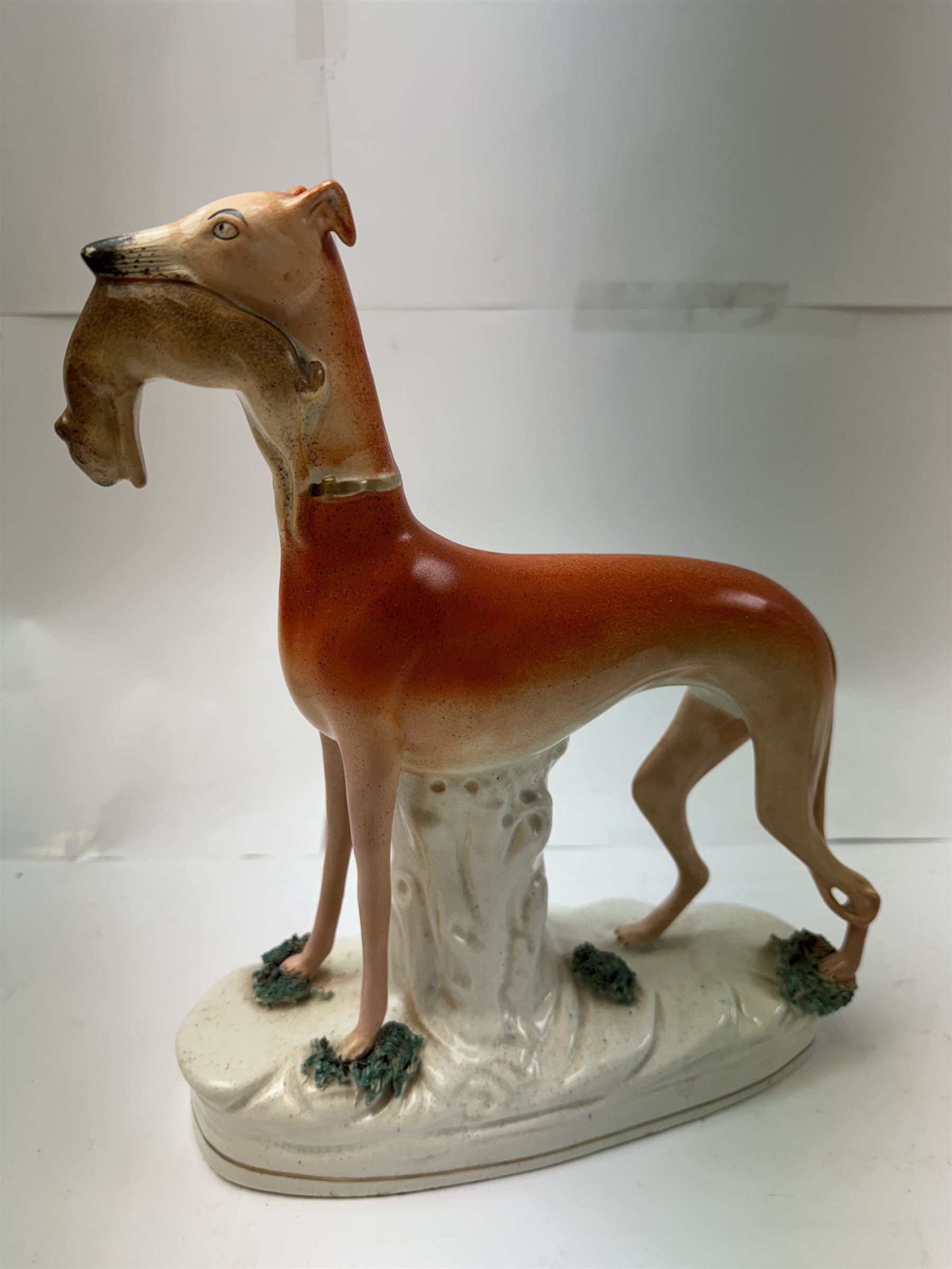 Pair of standing Staffordshire whippets with rabbits in their mouths, together with a pair of Staffordshire spaniels, whippets H30cm