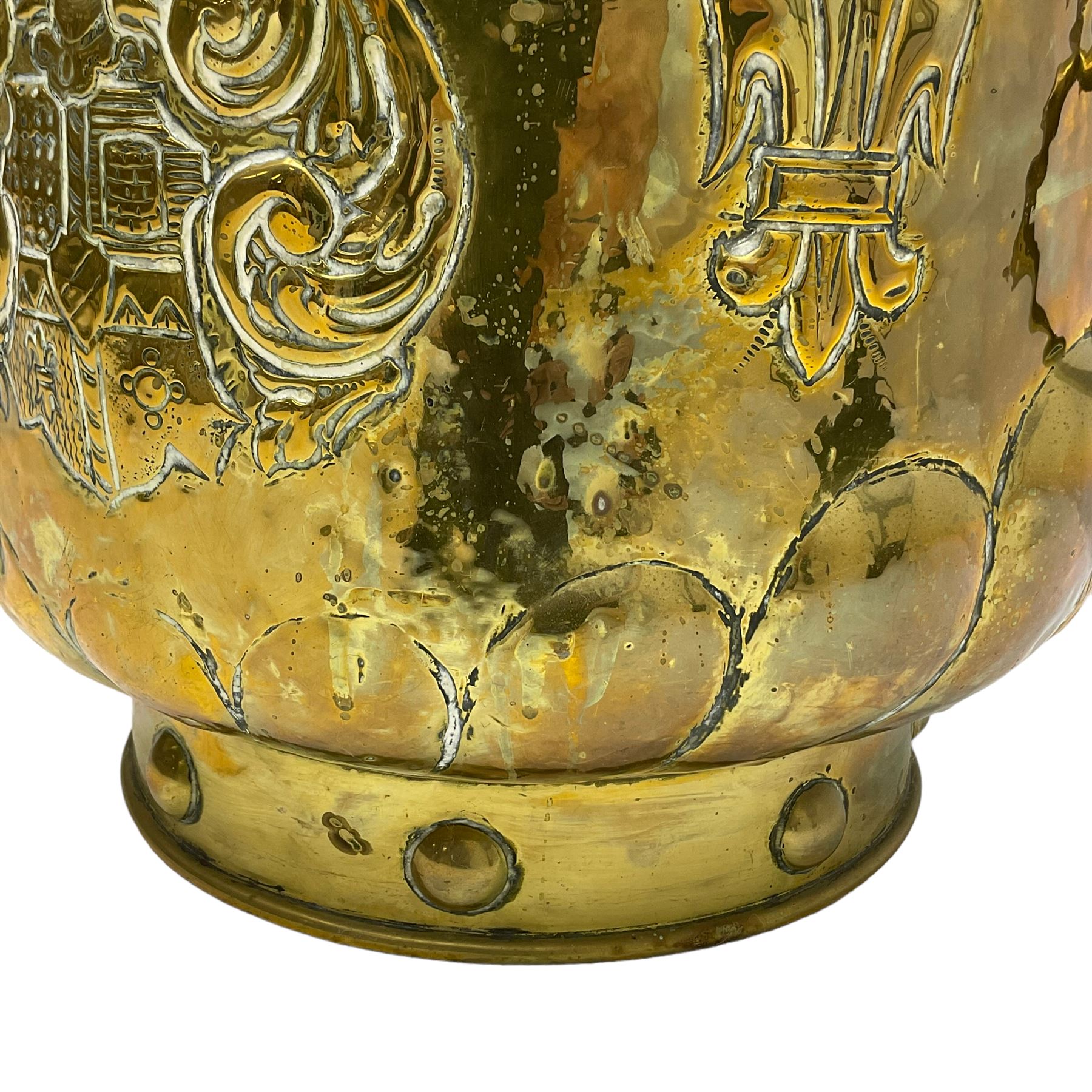 Early 20th century cylindrical brass coal or log bin, embossed with crest and fleur-de-lis motifs, gadrooned underbelly 