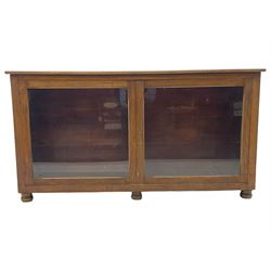 Early 20th century mahogany bookcase, rectangular top over two glazed doors, fitted with four adjustable shelves, on turned bun feet 