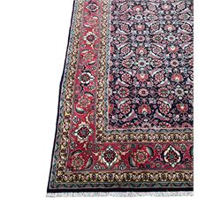 Persian Farahan indigo ground rug, the field decorated with large repeating floral herati motifs, crimson ground border decorated with palmettes and trailing leafy branch, within guard stripes 