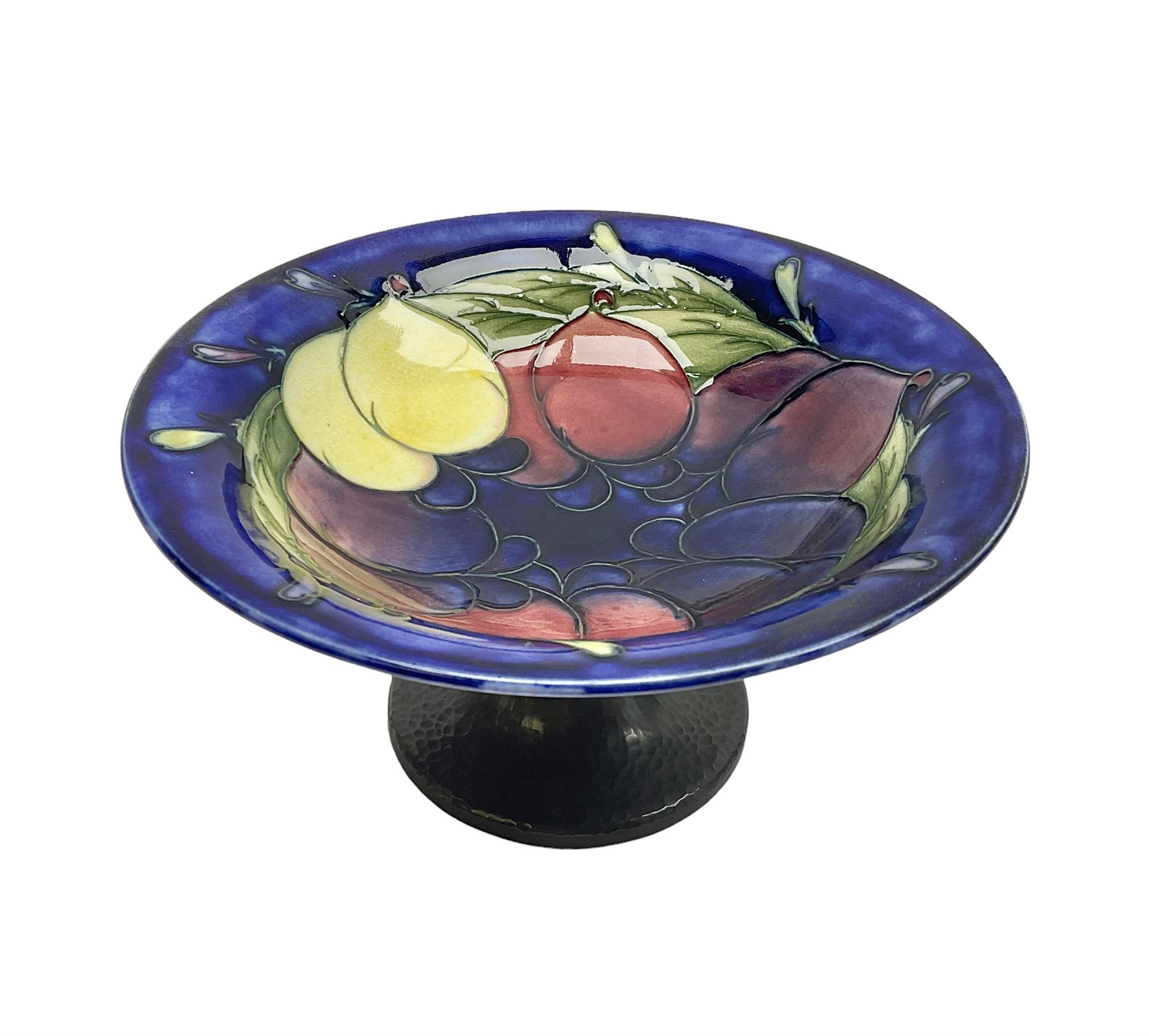 Moorcroft small pedestal dish decorated in the Wisteria pattern against a dark blue ground raised to a Tudric pewter stand, impressed beneath Tudric, Moorcroft, H9cm