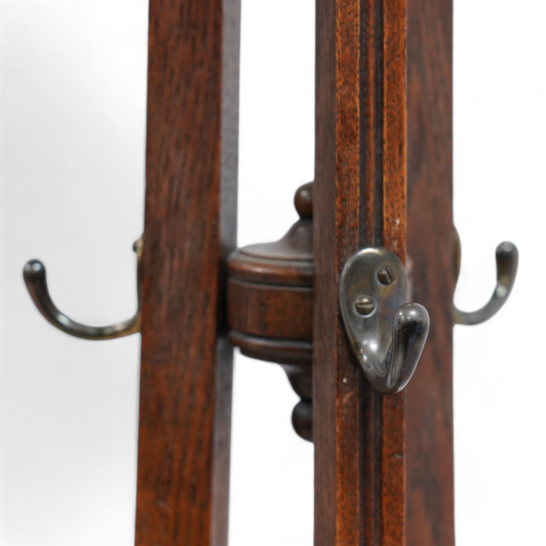 Late 19th century oak hat and coat hallstand, on three shaped and moulded supports with out splayed feet, fitted with hooks and turned finial 