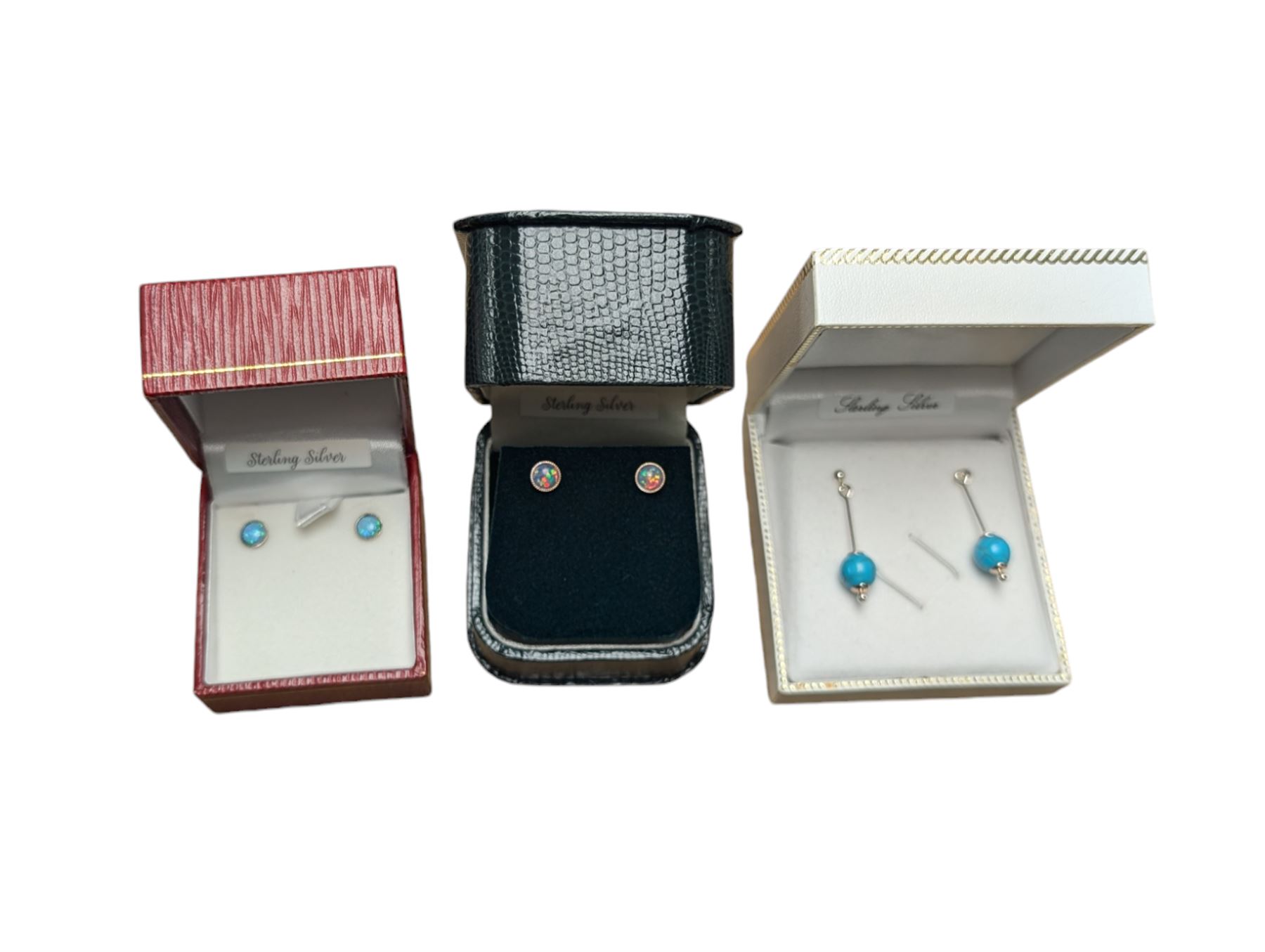 Three pairs of silver earrings, including a turquoise pair and two opal pairs, all boxed 