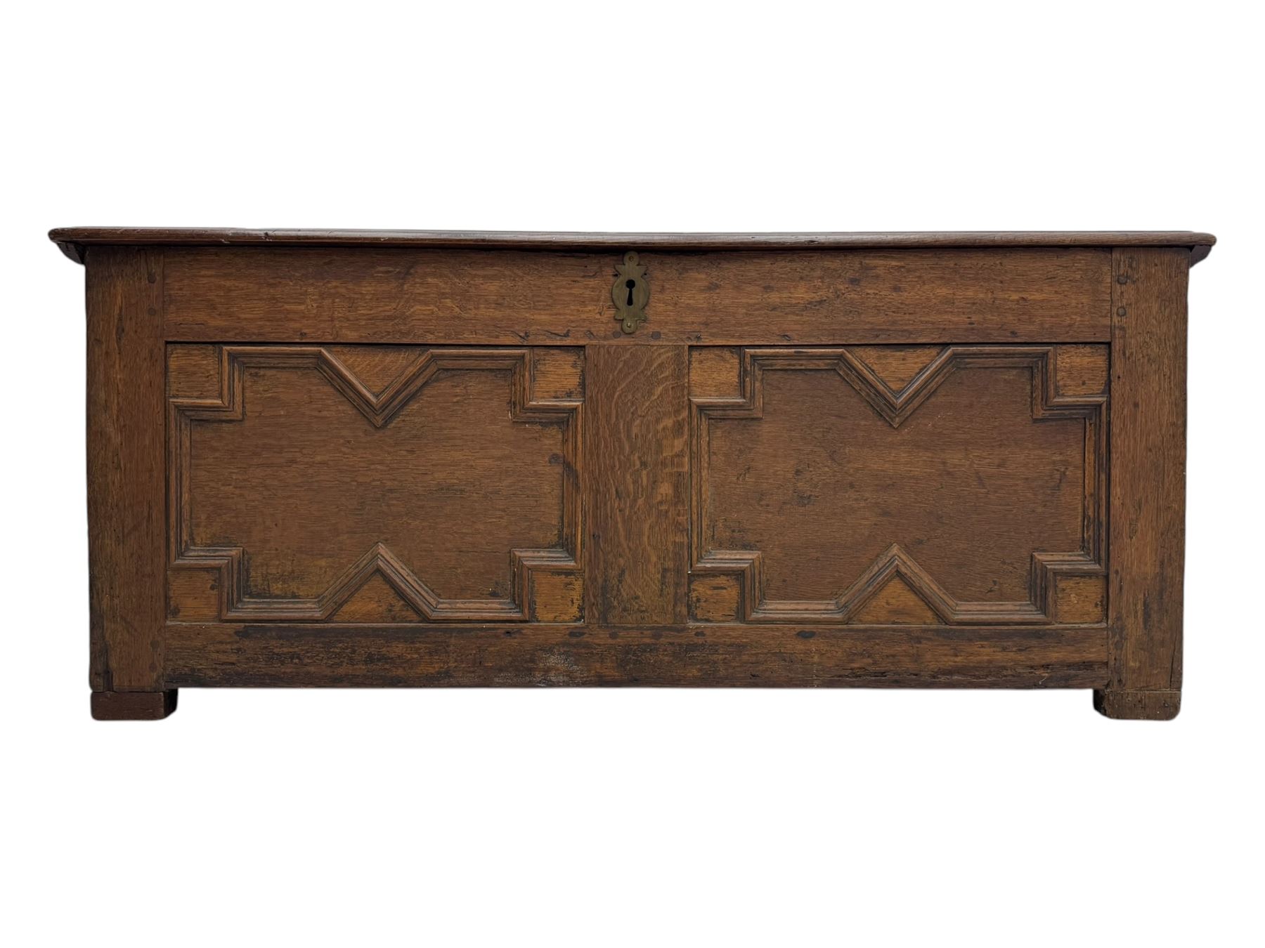 18th century oak blanket box, rectangular form with a hinged lid, the front decorated with raised geometric panelled mouldings, fitted with a central lock plate, raised on bracket feet