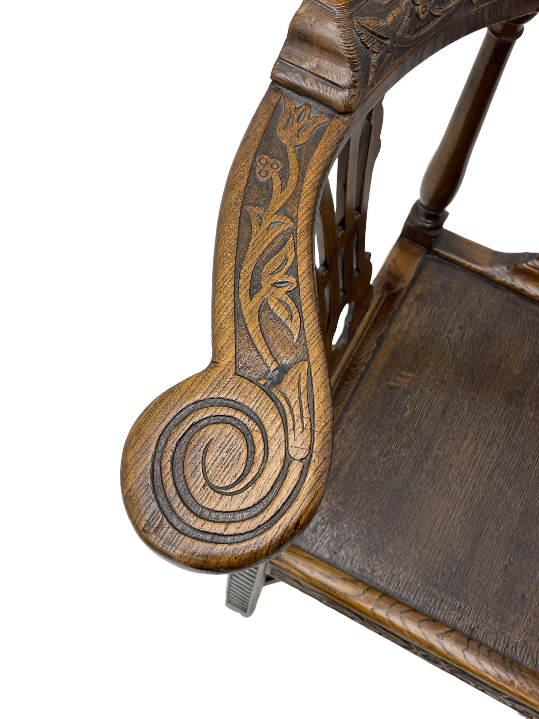 Elm 'Windsor' splat back corner armchair, shaped cresting rail carved with leaves over shaped and pierced splat, the curved arms carved with foliage and scrolled terminals, turned upper supports and a further two splats, panelled seat within foliate carved seat rails, on square rear supports with front shell carved cabriole support, united by plain x-frame stretchers