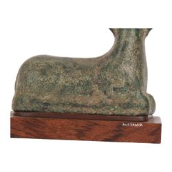 Bronze figure of a goat, probably Roman, modelled in recumbent position with legs tucked beneath body, upon later wooden plinth, overall H14.5cm W15cm