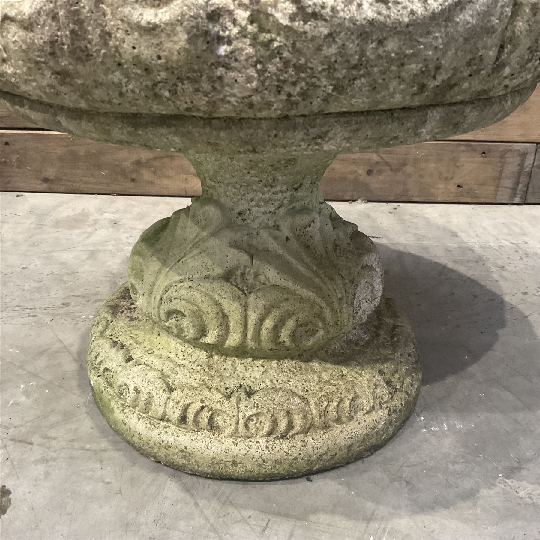 Cast stone circular garden urn decorated with scrolling foliate relief pattern