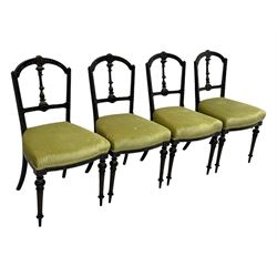 Set of four late Victorian ebonised dining chairs, decorated with carved and gilt foliate decoration, upholstered seats, on turned and fluted front supports 