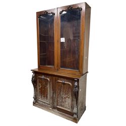 Victorian mahogany bookcase on cupboard, enclosed by two glazed doors, the base enclosed by two panelled doors flanked by acanthus carved upright pilasters, on plinth base