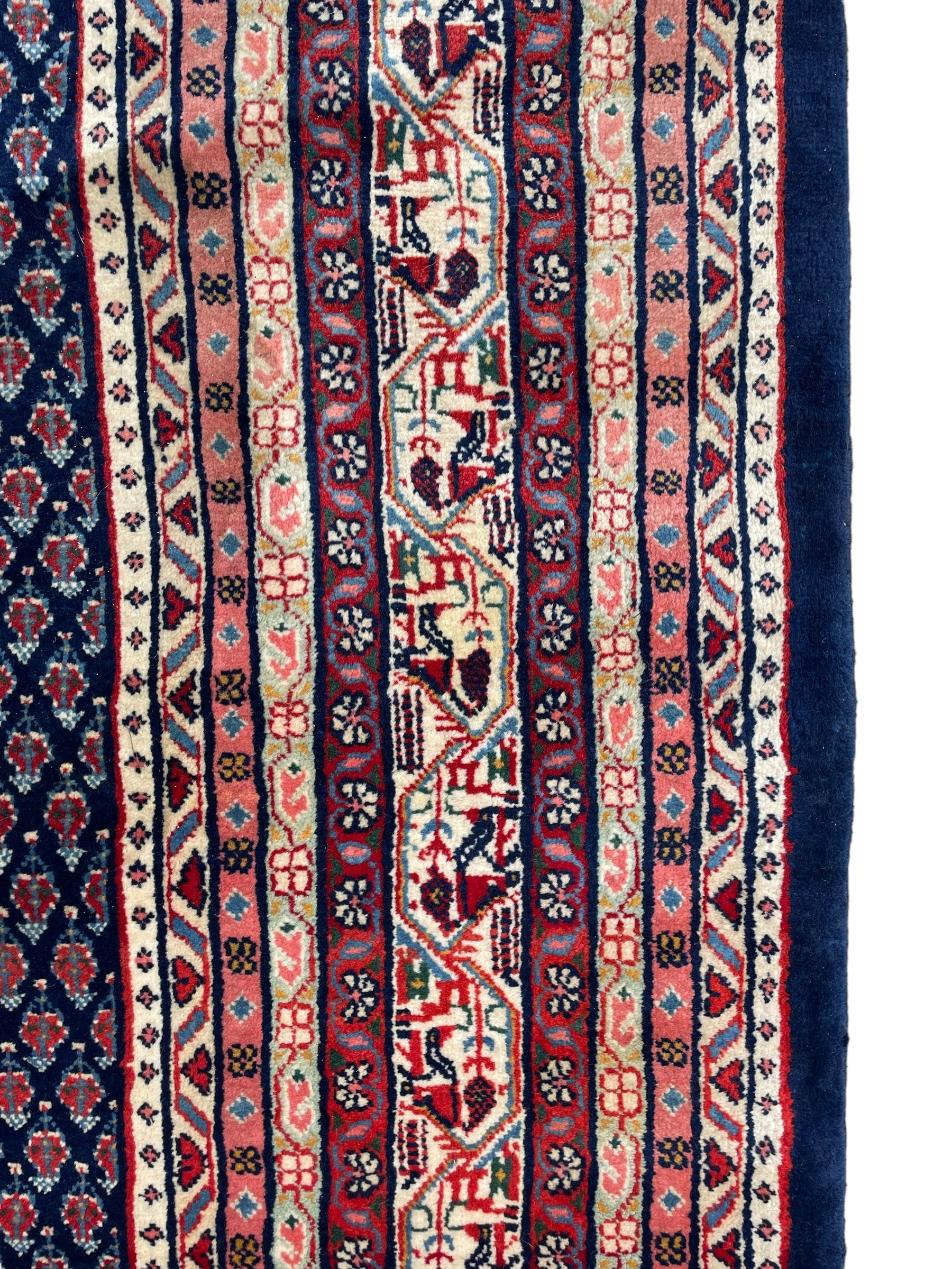 Large North-West Persian Arrak indigo ground carpet, the field decorated all-over with small Boteh motifs, multiple band border decorated with repeating geometric designs