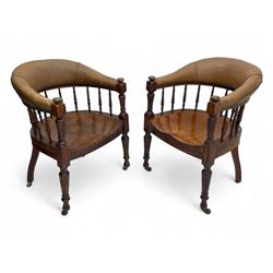 Pair of late Victorian walnut tub-shaped elbow chairs, the cushioned cresting rail upholstered in leather on spindle turned supports, dished saddle seat on turned supports