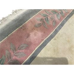 Chinese ivory ground washed woollen carpet, the field decorated with five large floral motifs with extending leafage, the wide rose guard band decorated with further floral patterns