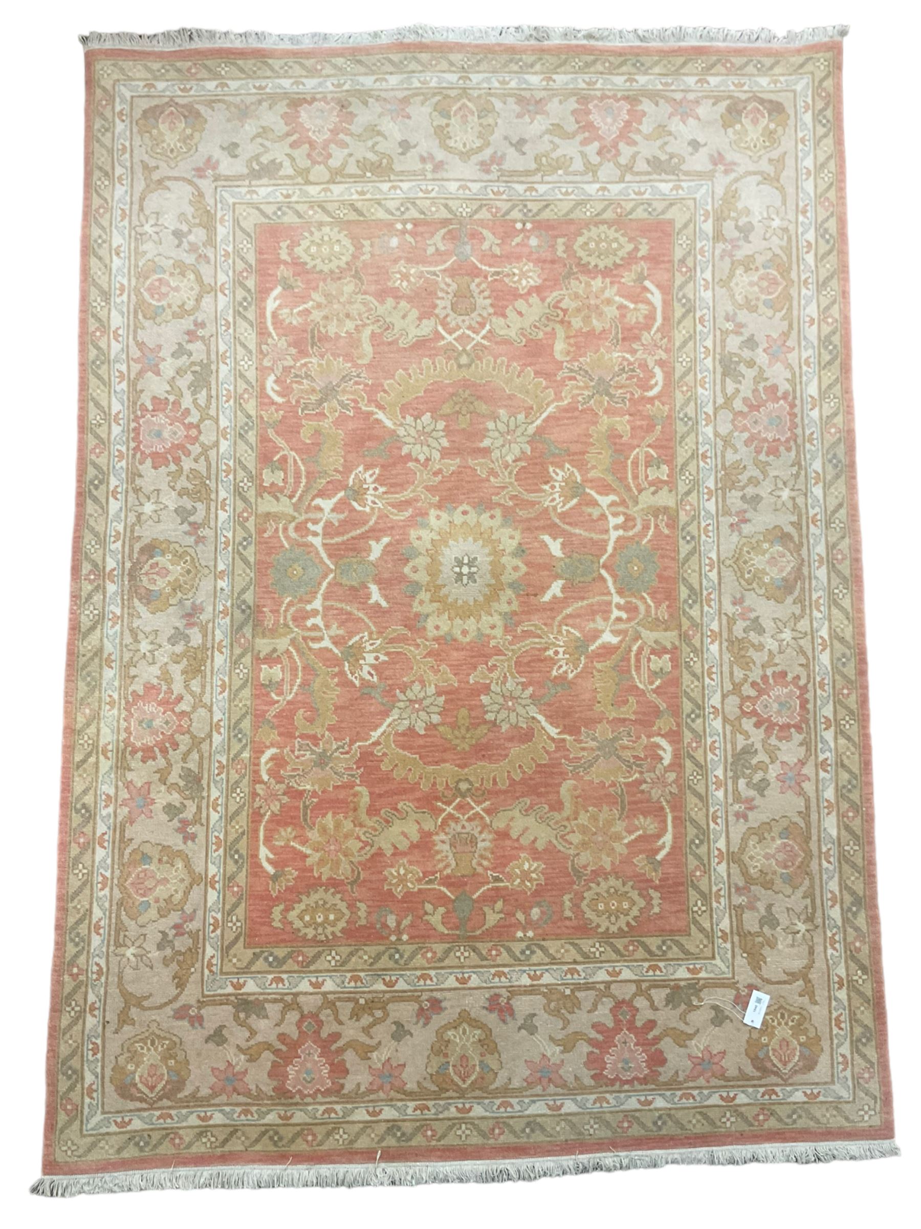 Persian Zeigler design rug, peach ground decorated with trailing branches and stylised plant motifs, the guarded border decorated with further plant moitfs