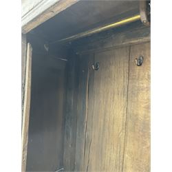 17th century and later oak hall cupboard, panelled front and sides with moulded frame, enclosed by single door with wrought metal hinges and handle, the interior fitted with hooks, on stile supports 