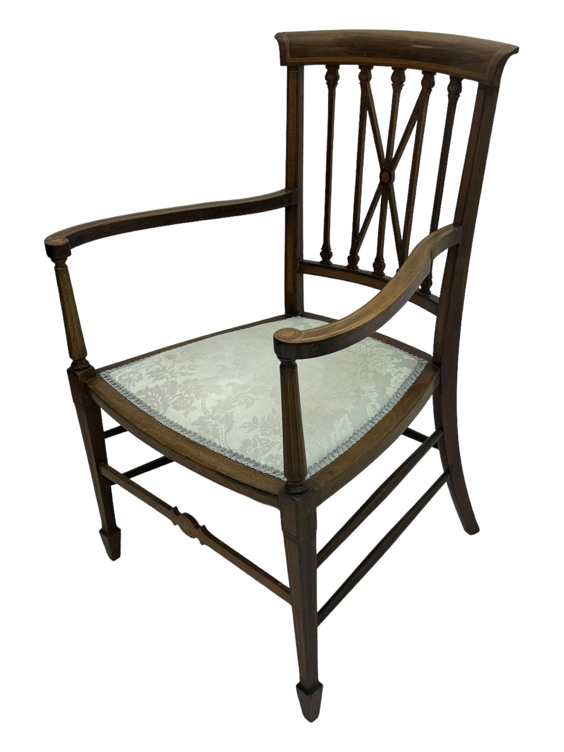 Edwardian inlaid mahogany armchair, curved top rail above spindle backrest with central X-shaped splat, the arms supported by turned uprights, over upholstered padded seat in pale blue damask fabric, on tapered supports with spade feet