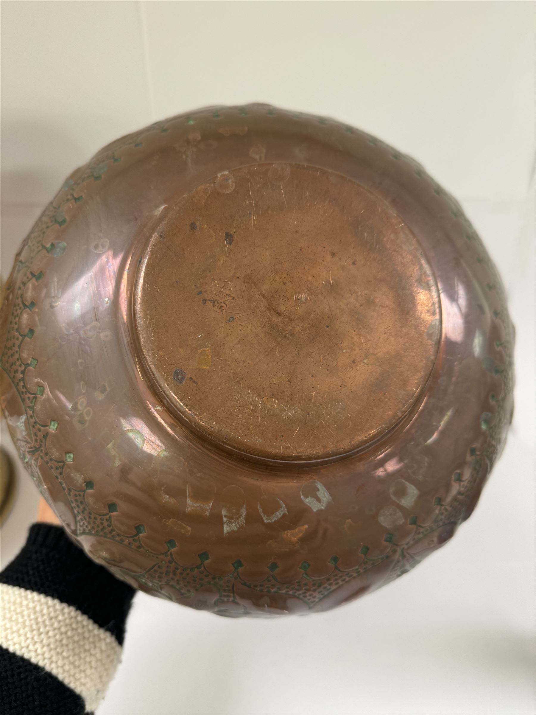 Middle eastern copper bucket, with chased and embossed band of animal decoration, together with a copper jardinière embossed with floral panels, copper plate with embossed leaf motif and two brass helmet shaped coal scuttles, bucket H26cm