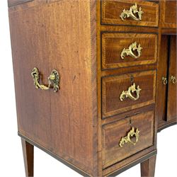 Late 19th century mahogany and satinwood dressing chest, the raised middle section hinges to reveal an interior fitted with lidded compartments, removable tray, single drawer and glass scent bottles, lift-up bevelled mirror with adjustable hinged mechanism, fitted with a further eight cock-beaded graduating drawers and curved kneehole with double cupboard, square tapering supports on brass cups and castors, inlaid throughout with checkered stringing, ornate Rococo cast gilt metal handles