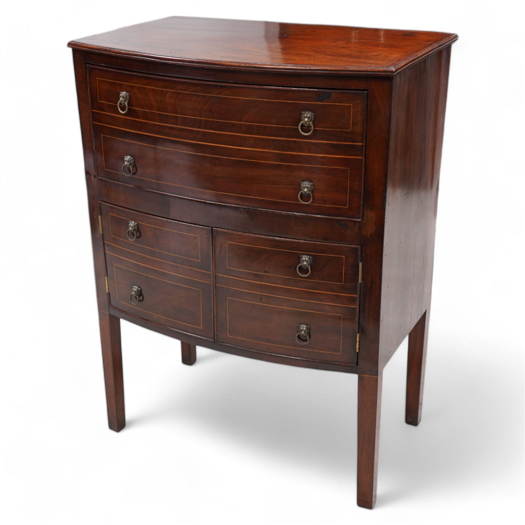 George III mahogany bow-fronted night cabinet, moulded top with box wood stinging over single drawer and double cupboard, with lion mask and hoop handles, on square supports 