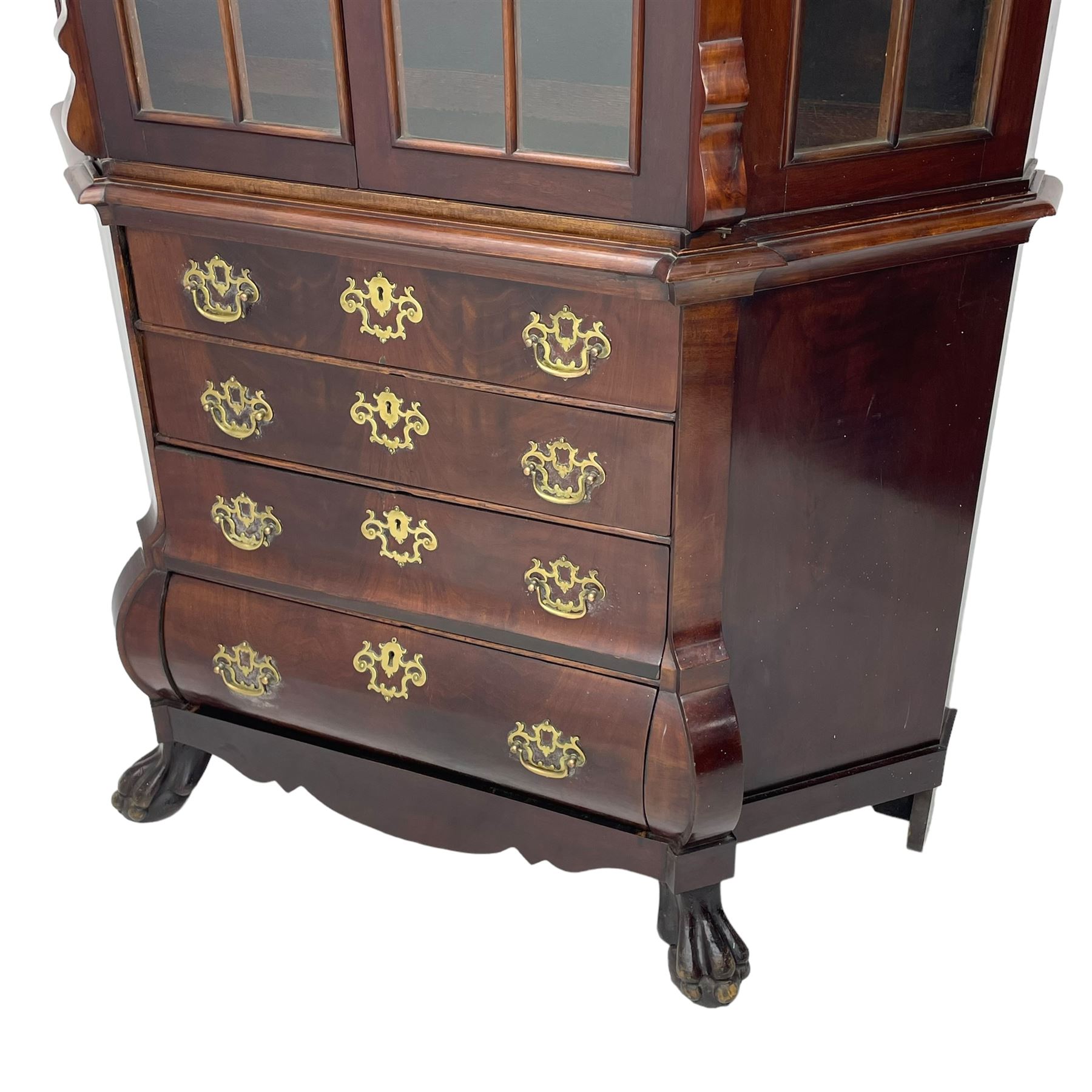 19th century Dutch mahogany vitrine on chest, shaped moulded pediment with central C-scroll and flowerhead carved mount, enclosed by two astragal glazed doors, the interior fitted with fabric lined shelves, four graduating long drawers below, on ball and claw carved feet 