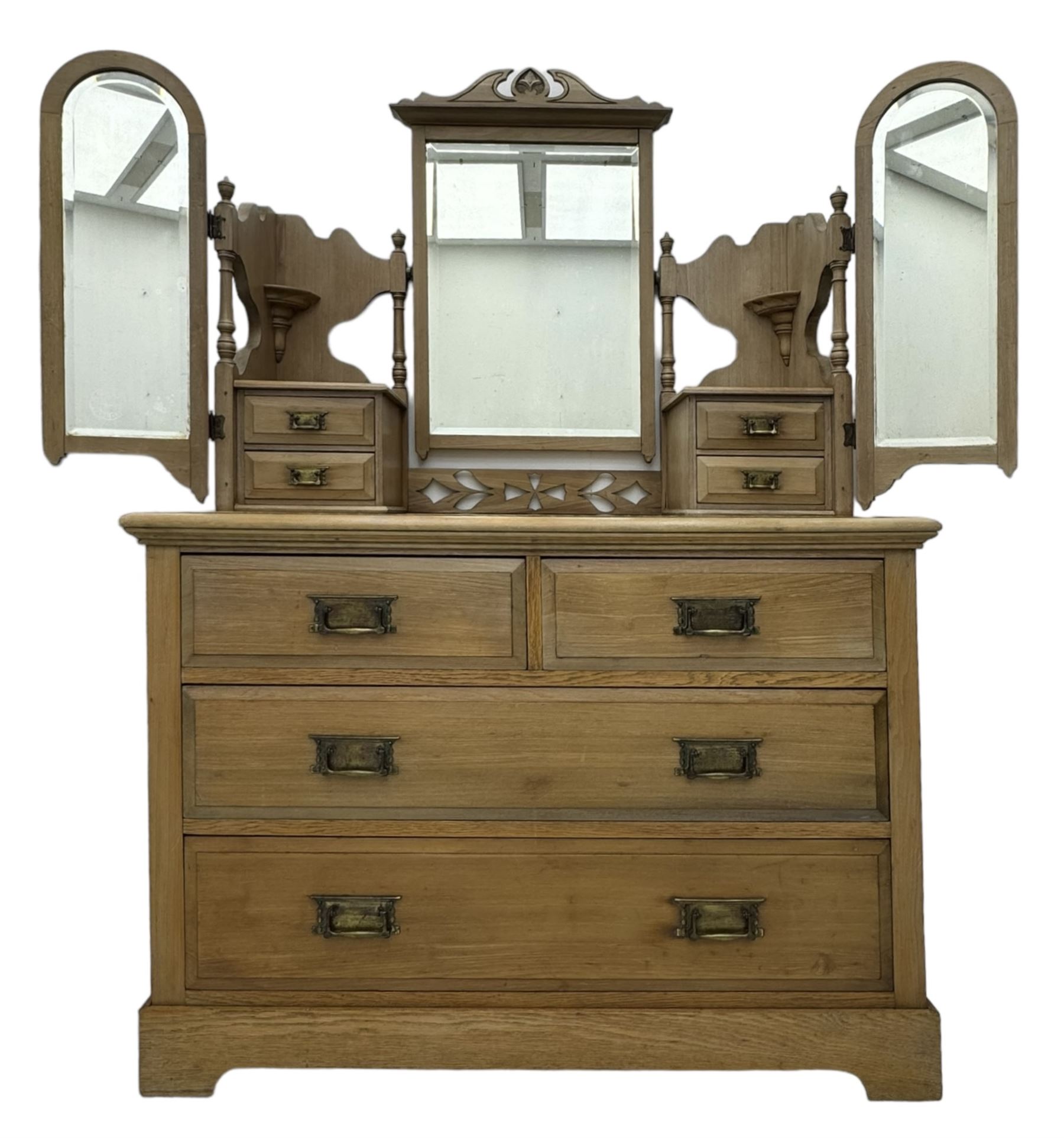 Late Victorian satin walnut dressing table, central mirror with carved crest flanked by two adjustable side mirrors, each supported by turned uprights, the base fitted with two short over two long drawers with brass handles, resting on bracket feet