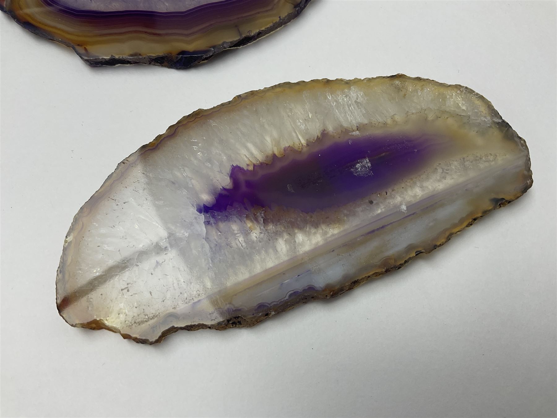 Three purple agate slices, polished with rough edges, of various sizes largest H7cm, L10cm