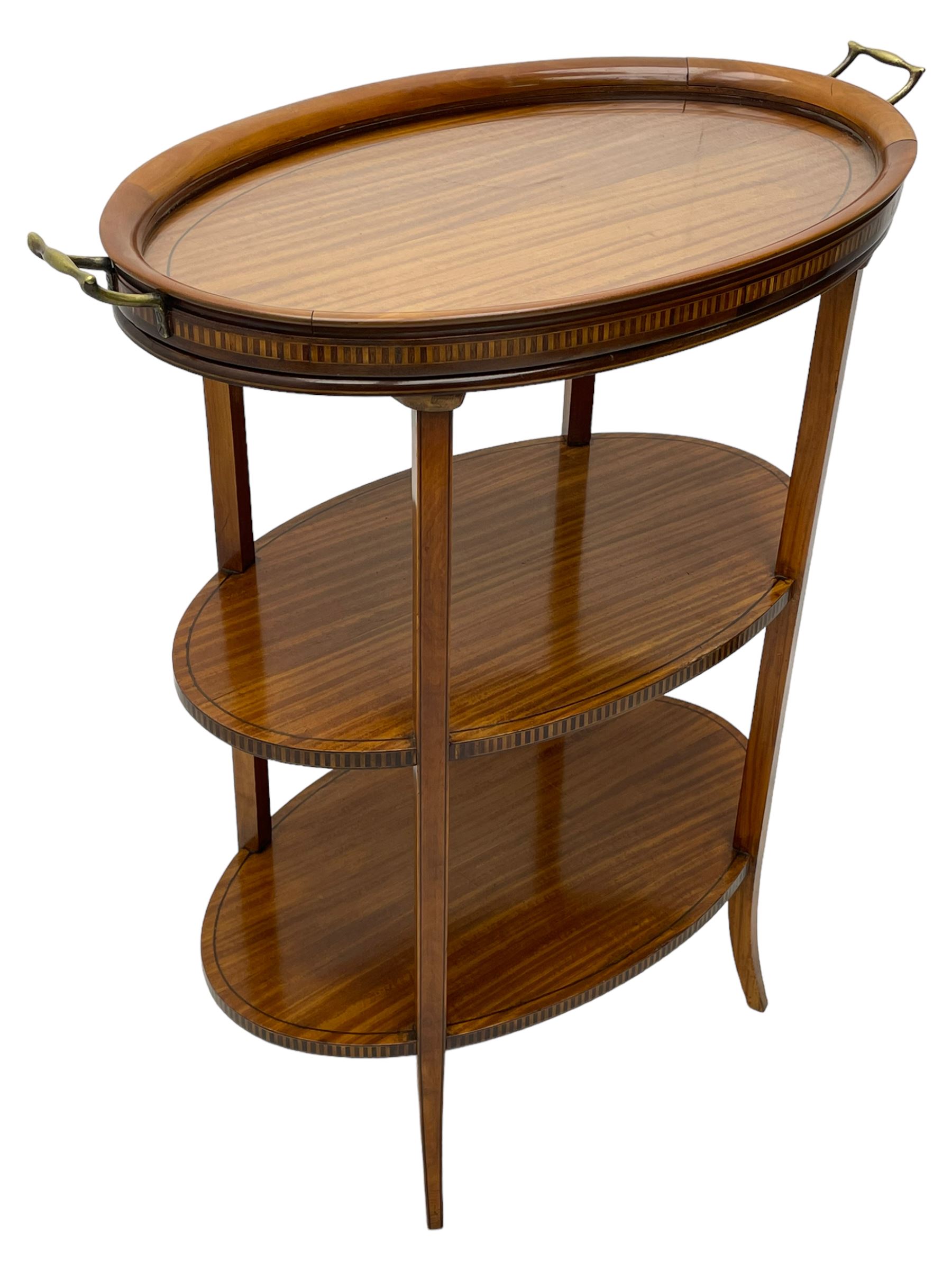 Edwardian satinwood tray top stand of oval form, tray top with glazed base and brass handles over two tiers, each with checkered inlaid band, on square tapering and splayed supports