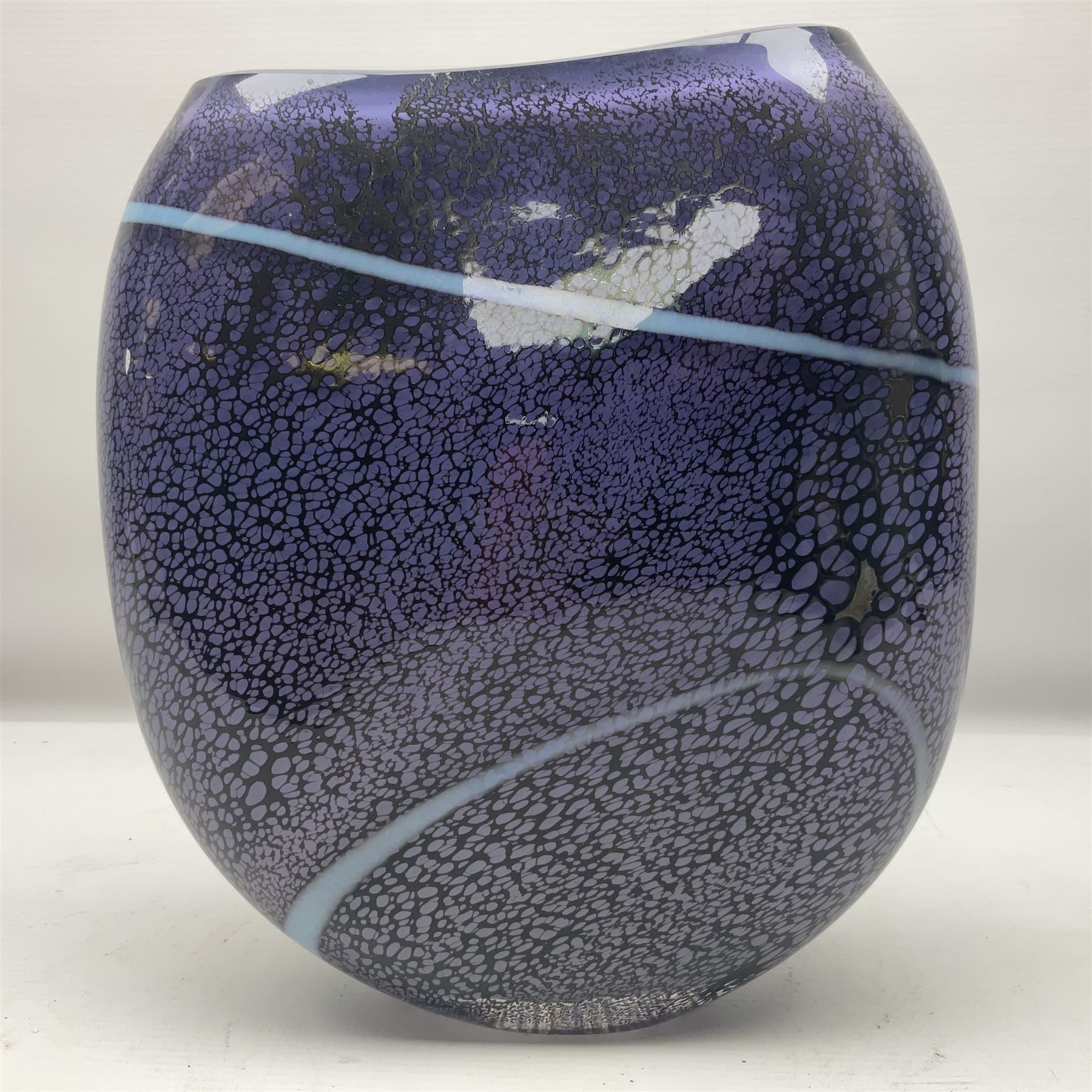 Stuart Akroyd glass vase, with blue ribbon decoration upon a mottled purple ground, engraved signature and sticker beneath, H25.5cm