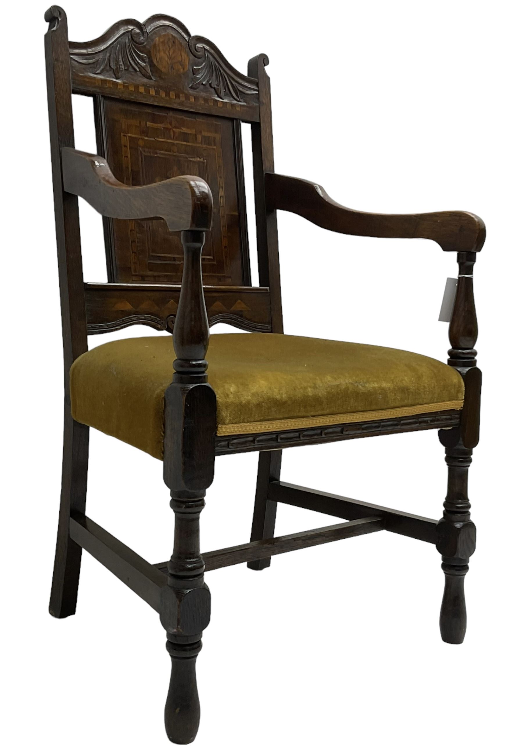 Late 19th to early 20th century oak elbow chair, the shaped cresting rail carved with scrolls and foliage, panelled back inlaid with parquetry work and central rampant lion within shield, upholstered seat, on turned supports joined by H stretchers