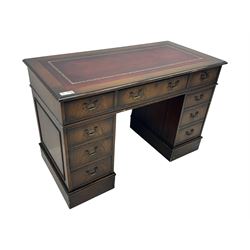 20th century mahogany twin pedestal desk, moulded rectangular top with red leather inset with gilt tooled border, central drawer over kneehole flanked by two banks of four graduating cockbeaded drawers, on plinth base