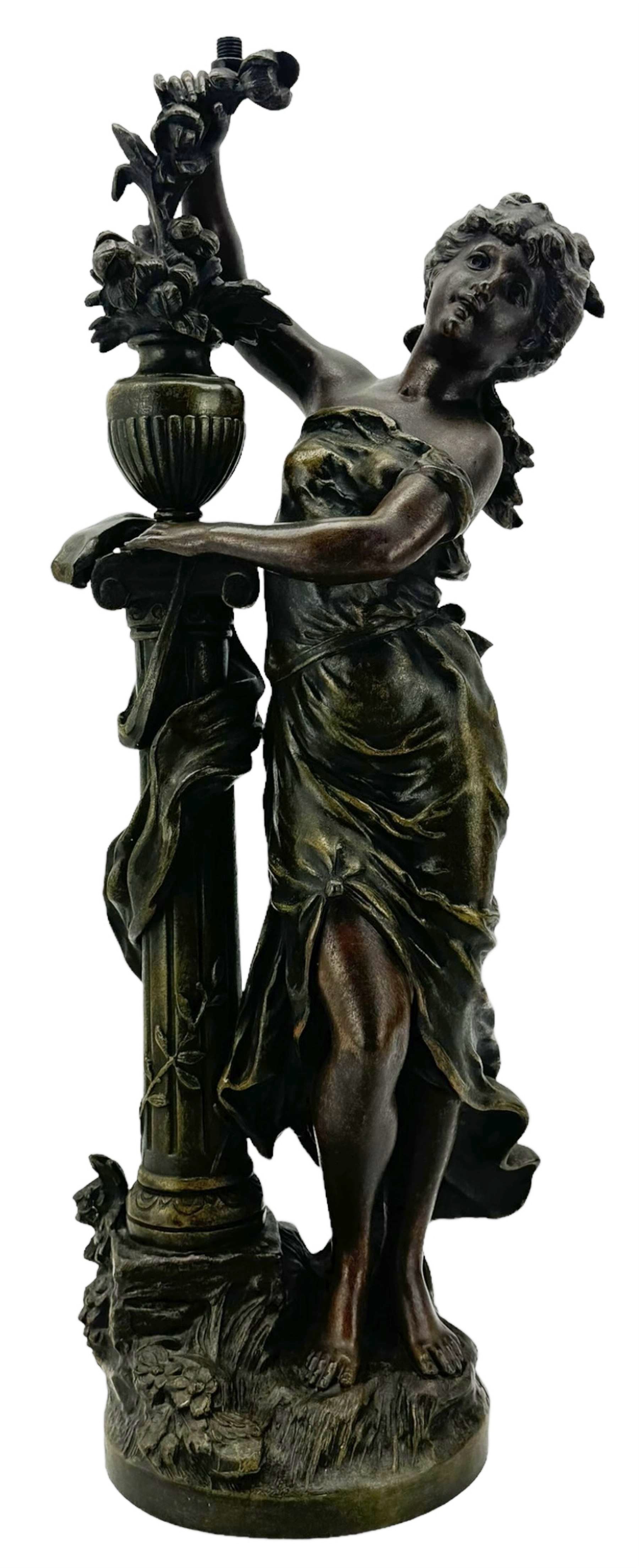 After L & F Moreau - Spelter table lamp in the form of a female figure next to a pedestal on circular naturalistic base H55cm