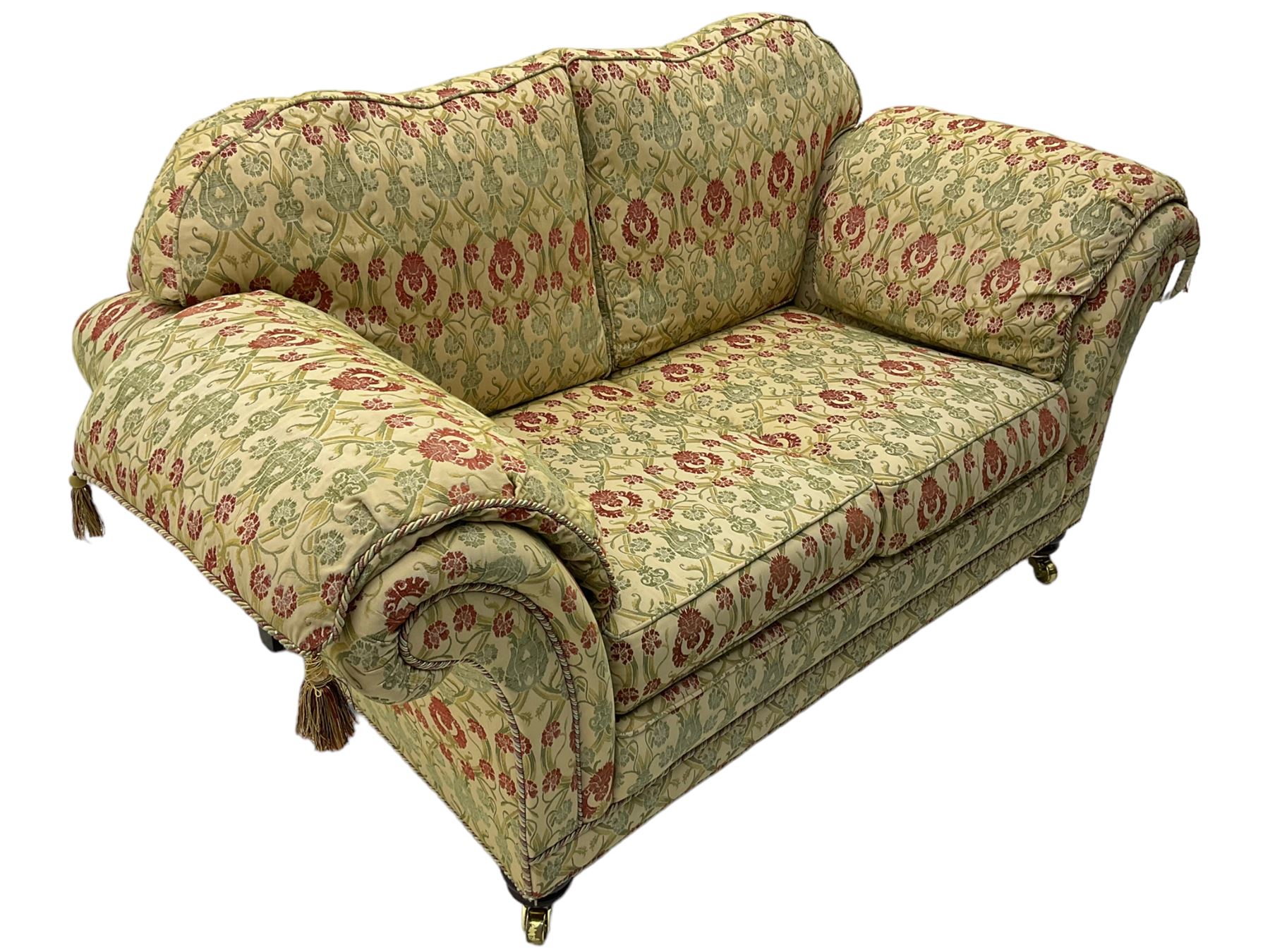 Traditional design two seat sofa, high back with scrolled arms, upholstered in beige fabric with red and green damask motifs, on castor supports (L178cm, D100cm, H89cm); matching armchair (L109cm, D89cm, H89cm)