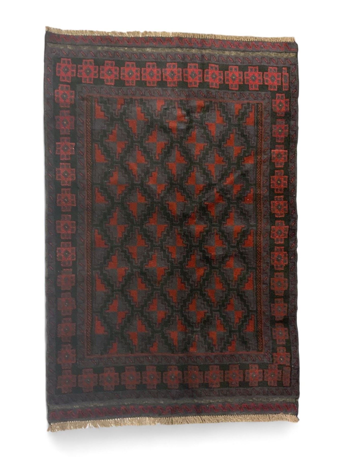 Baluchi indigo ground rug, the field decorated with all-over crimson and indigo lozenges, enclosed by geometric guard lines