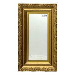 Rectangular wall mirror, in ornate gilt frame decorated with trailing leafy branches and flower heads 