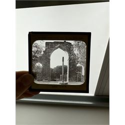 Collection of magic lantern slides, predominantly depicting views of India, with scenes including including the Taj Mahal, tombs, monuments, street scenes, people and animals, in compartmentalised wooden case 