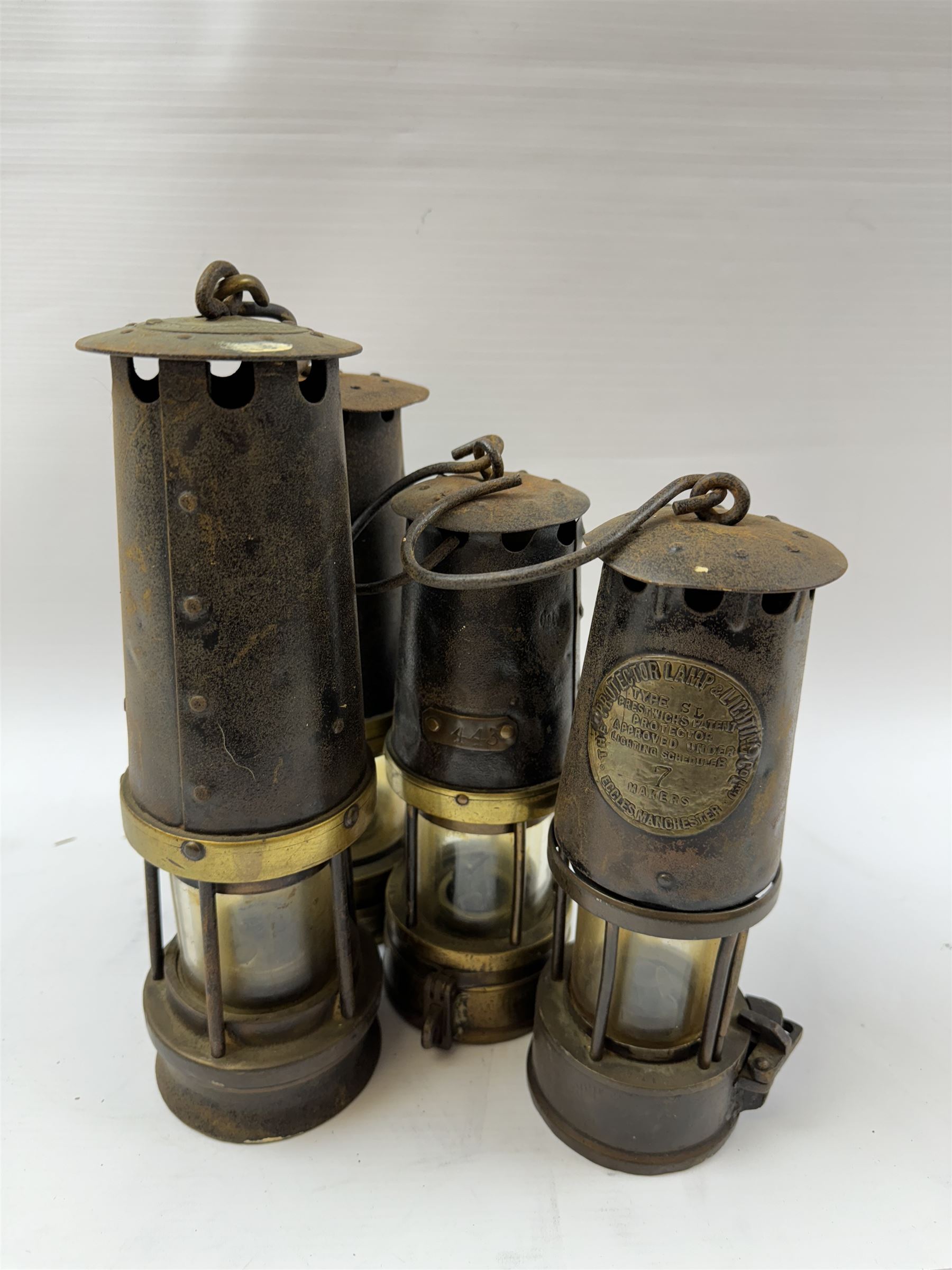 Four miners lamps, including Eccles Manchester example, tallest H30cm