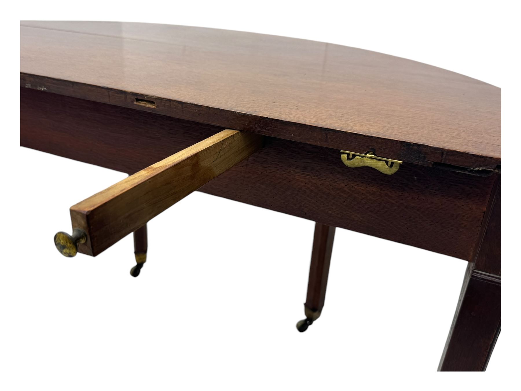 Early 19th century mahogany demi-lune extending dining table, two D-ends with central leaf insert, raised on eight square supports with arched spandrels terminating in brass castors