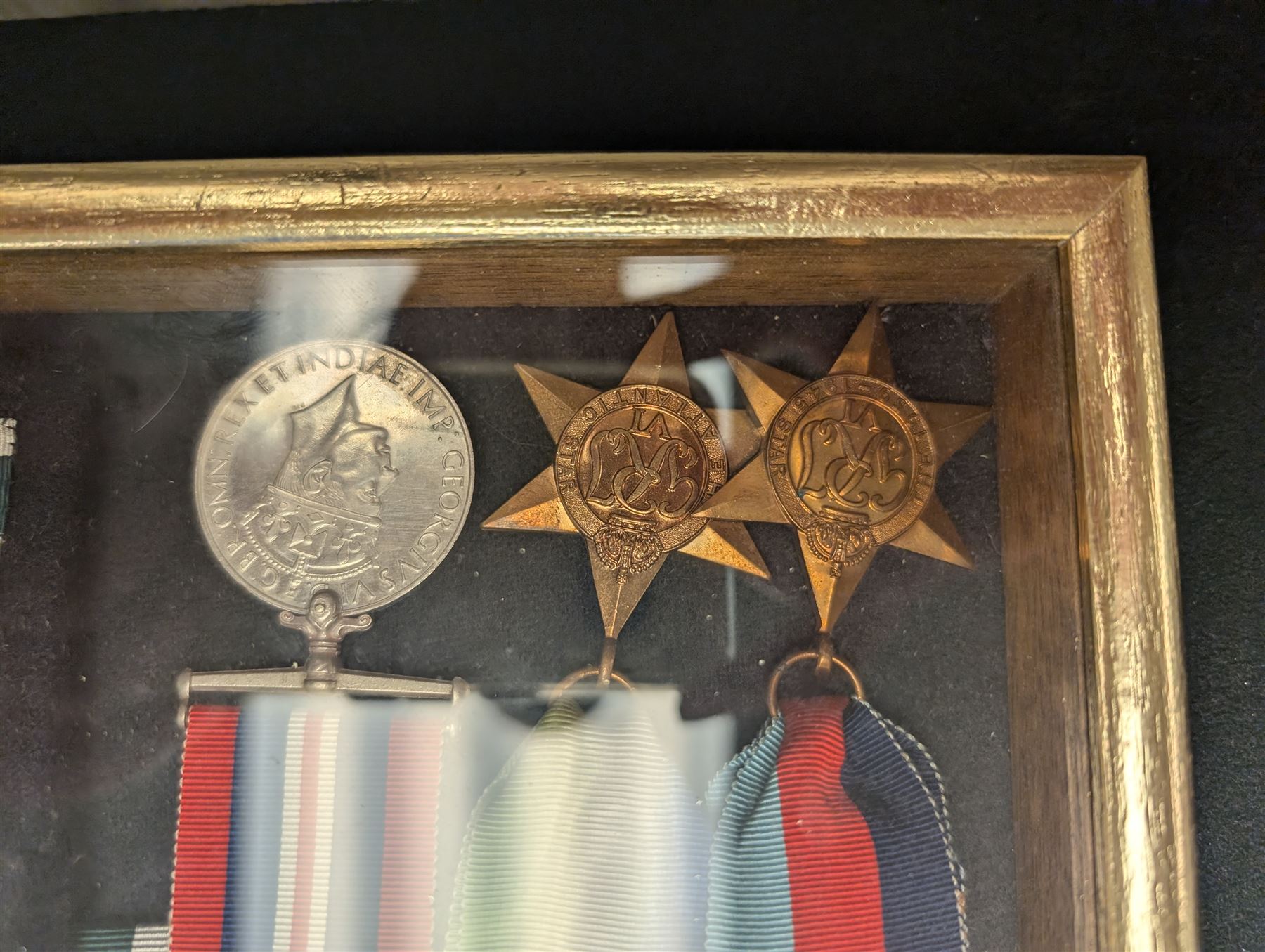 World War II medal group, including Atlantic Star and General Service medal, inscribed Thomas Crawford in glazed display frame