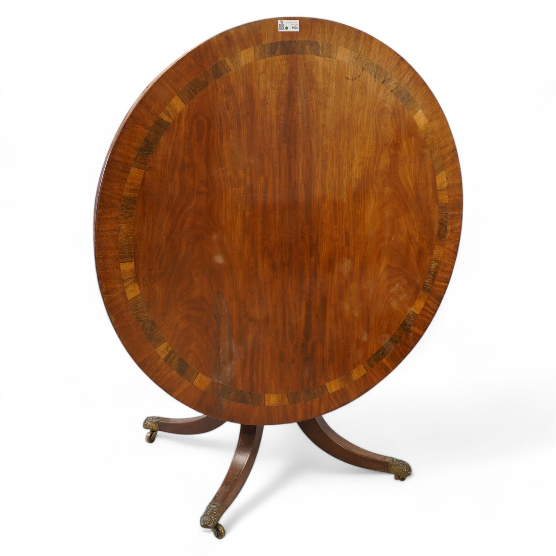 George III mahogany and rosewood banded breakfast or centre table, circular tilt-top with figured veneers and rosewood band, on turned column with four out-splayed supports, ornate cast brass castors 