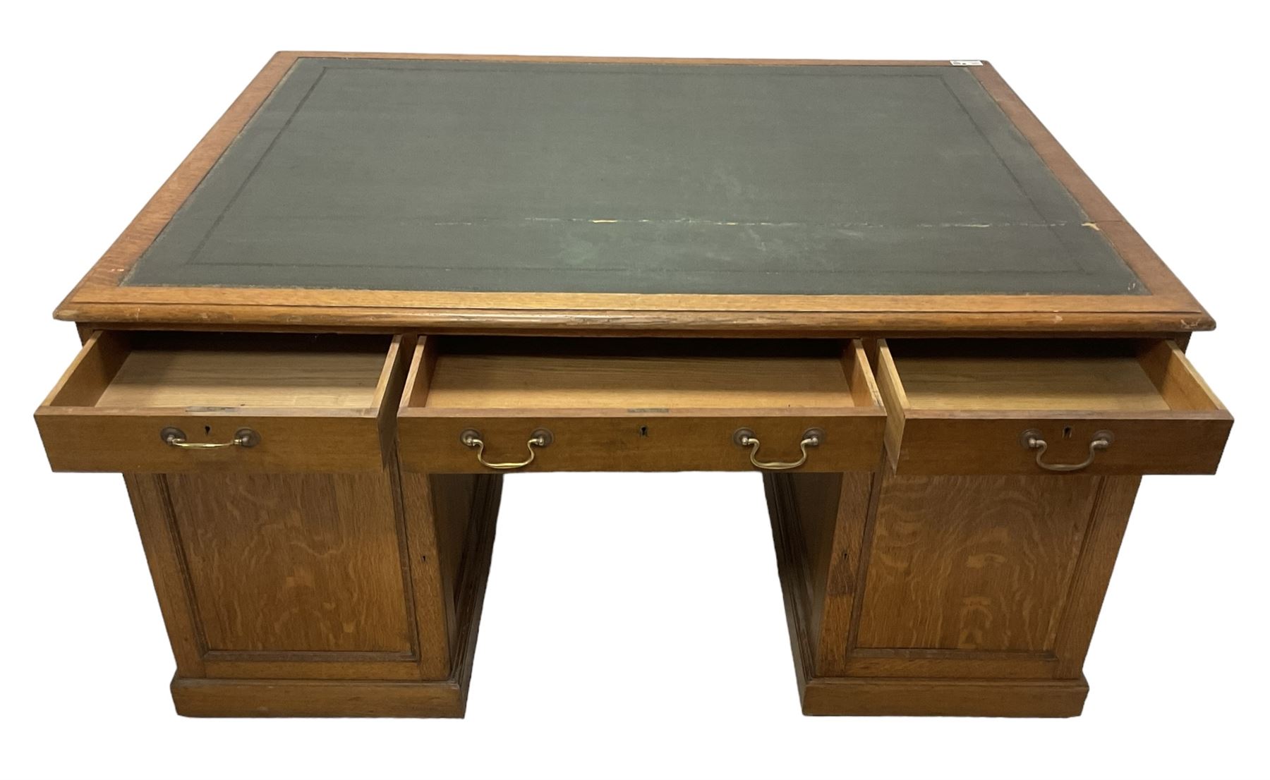 Late 19th century twin pedestal oak partner's desk, rectangular top with inset green leather writing surface, fitted with nine graduating drawers to each side, the rear drawers enclosed by panelled cupboards