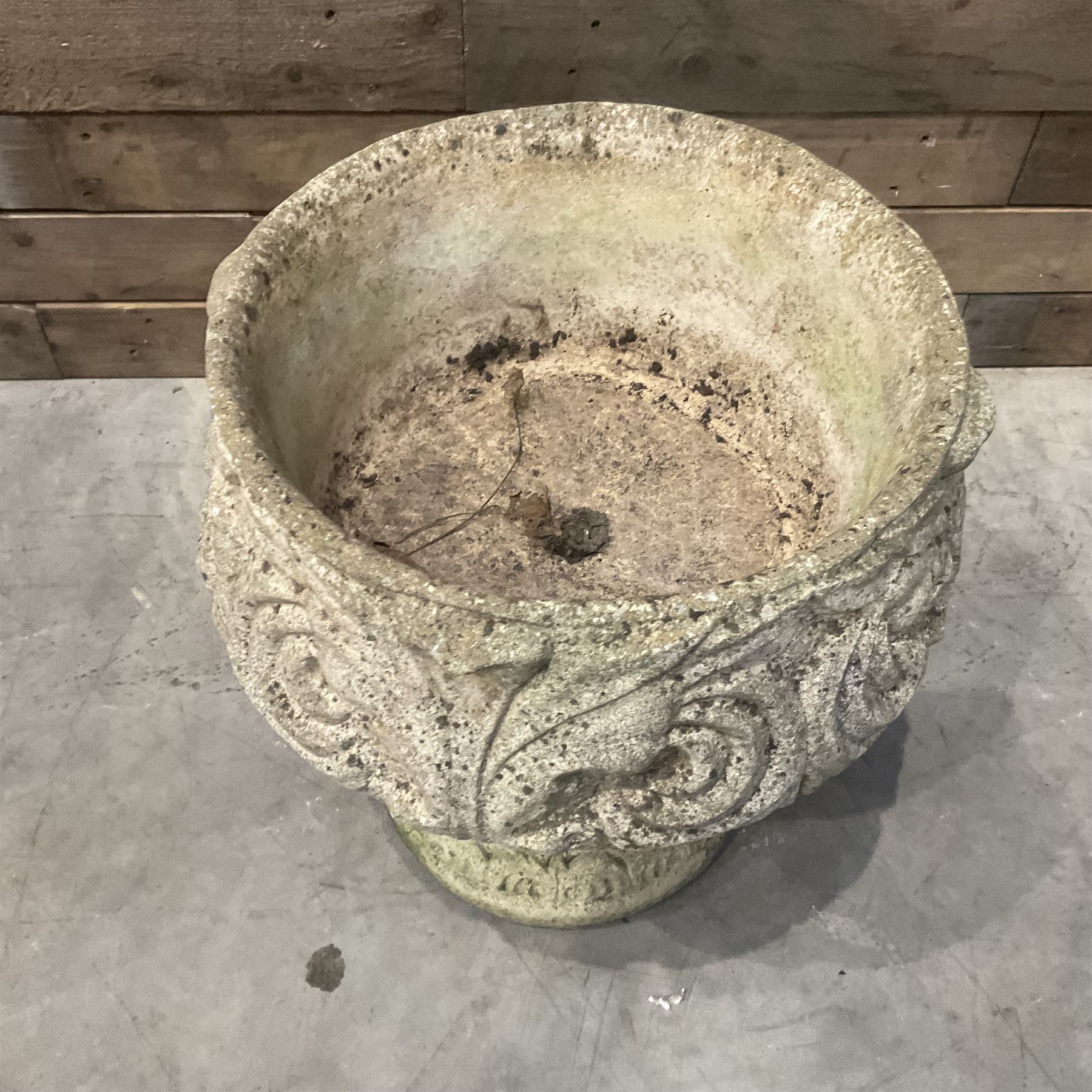 Cast stone circular garden urn decorated with scrolling foliate relief pattern