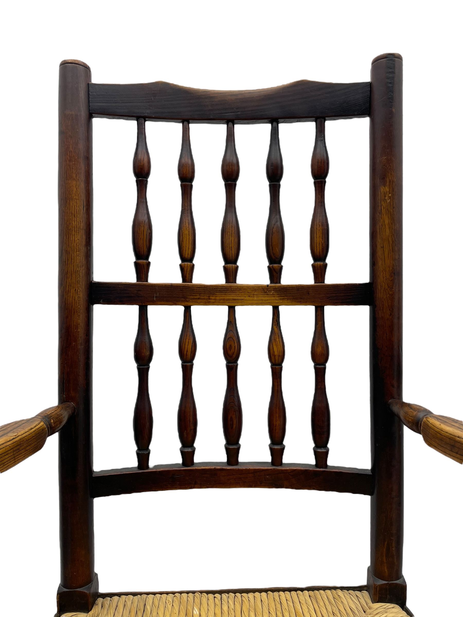 Matched set of twelve 19th century elm Lancashire spindleback dining chairs, shaped cresting rail over spindle back, rush seat, on turned supports united by turned stretchers, ring and globular turned front stretcher 